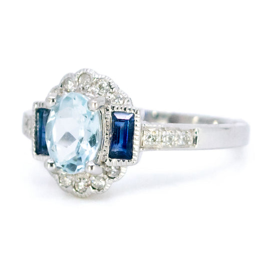A white gold cluster ring with aquamarine, sapphires and diamonds