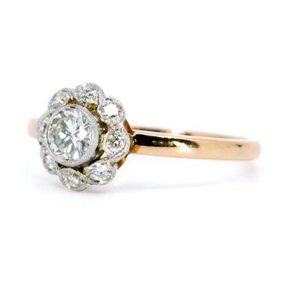 A round diamond cluster ring in gold and platinum