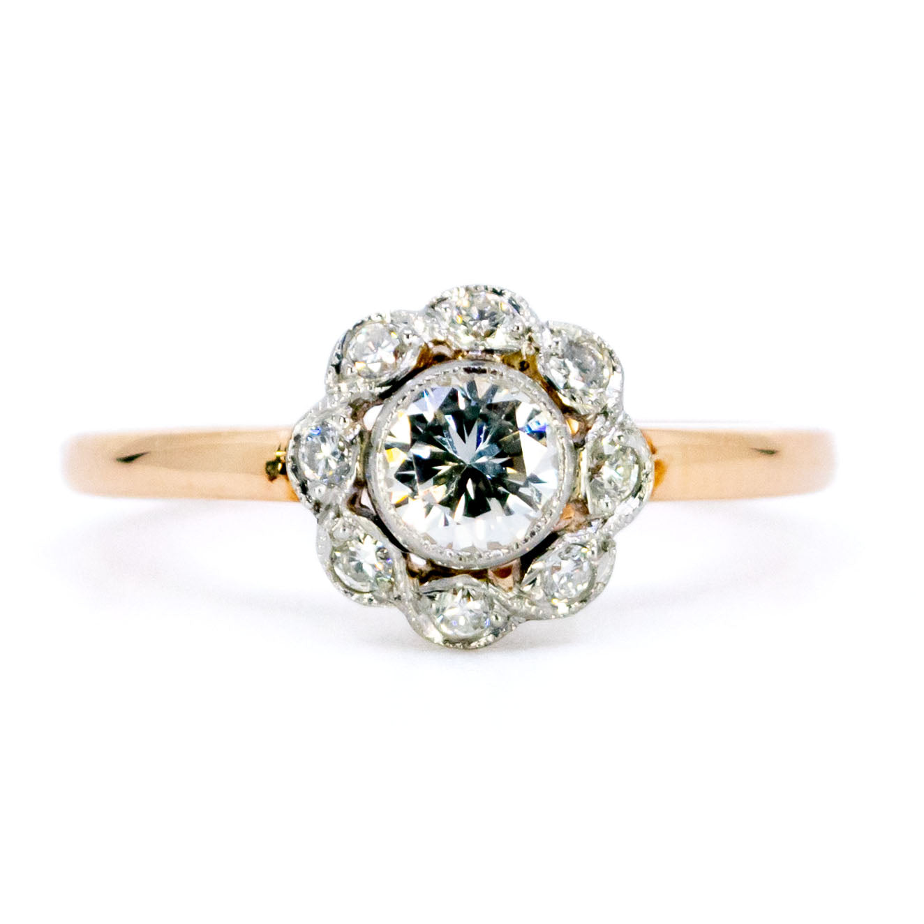 A round diamond cluster ring in gold and platinum