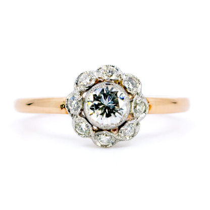 A round diamond cluster ring in gold and platinum