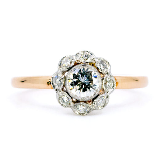 A round diamond cluster ring in gold and platinum