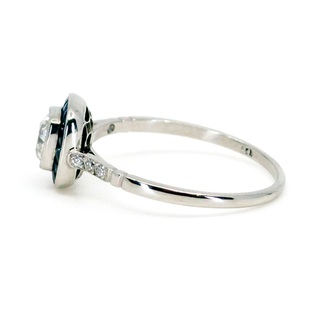 A cushion cut diamond halo cluster ring with sapphires in platinum