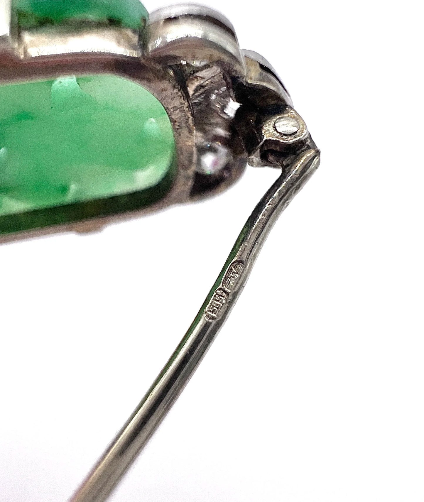 Stamps on a white gold brooch pin