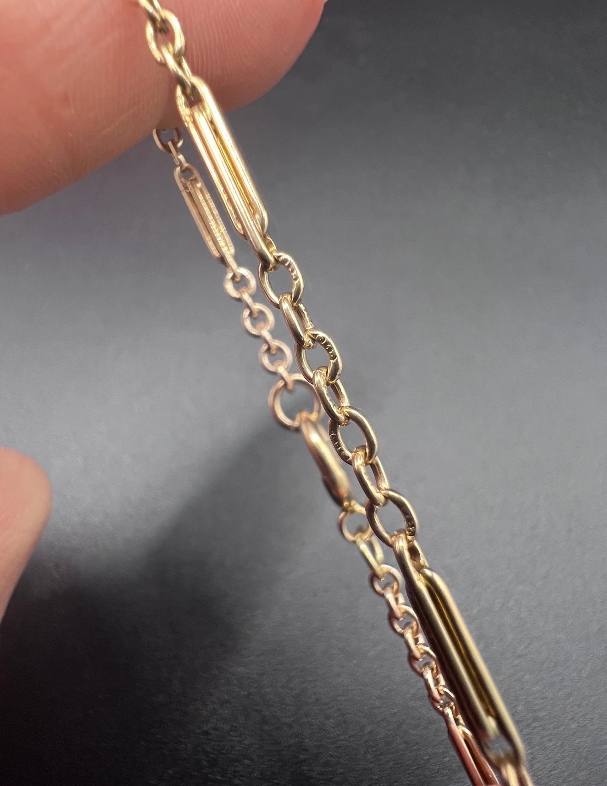Close-up of stamps on yellow gold bracelet links