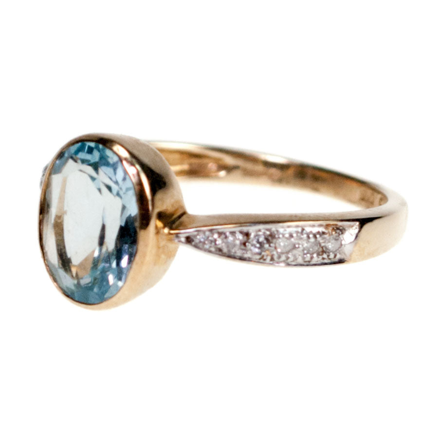 An oval blue topaz and diamond ring in yellow gold