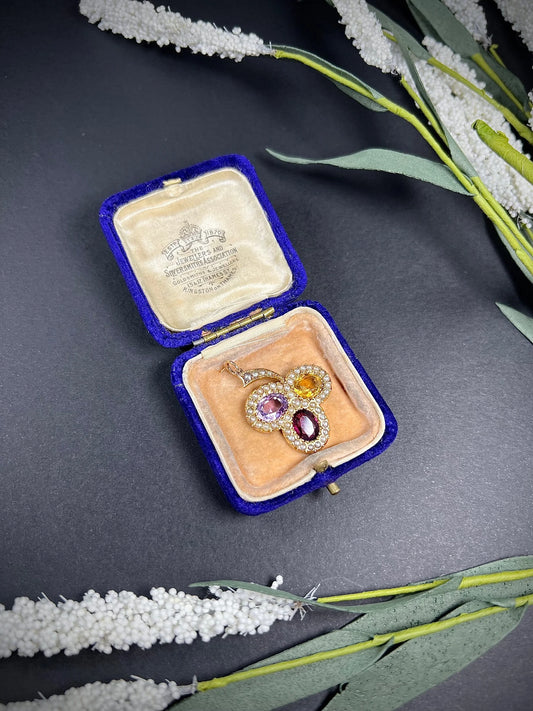 A yellow gold clover pendant with amethyst, citrine, garnet and seed pearls, in an antique box