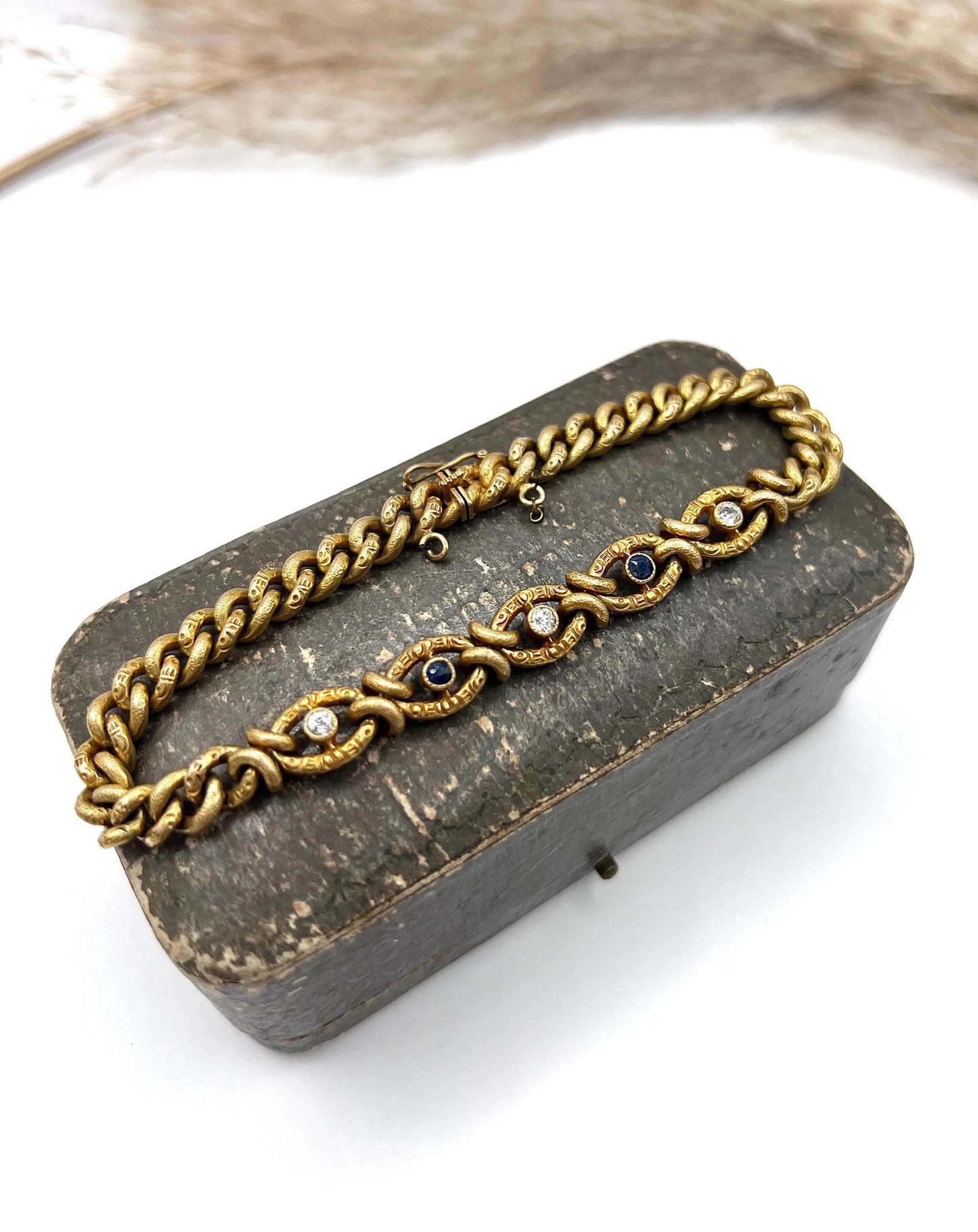 A sapphire and diamond fancy curb link bracelet in yellow gold