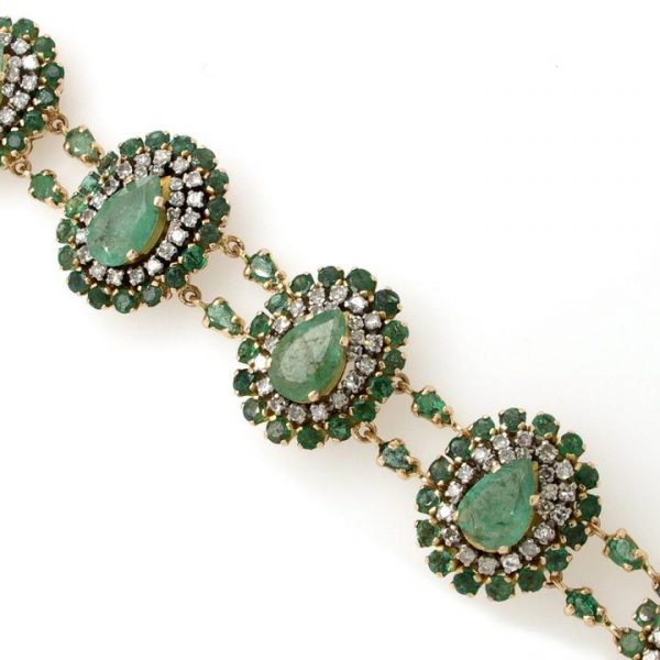 Vintage Emerald, Diamond and Gold Cluster Bracelet; featuring seven articulated clusters with central pear-shaped emeralds within diamond and emerald surrounds, Circa 1970s