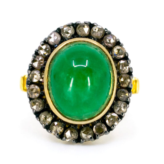 An oval emerald and diamond cluster ring in yellow gold and silver