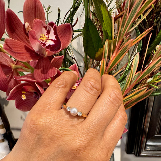 A three stone pearl and diamond ring in yellow gold, modelled on a hand