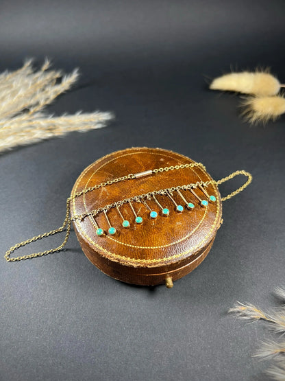 A gold negligee pendant necklace with turquoise drops