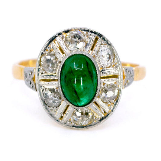 A cabochon cut emerald and old cut diamond oval cluster ring in yellow and white gold
