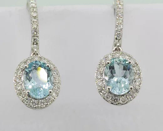 Aquamarine and Diamond Oval Cluster Drop Earrings; oval aquamarine and diamond clusters suspended from diamond set hoops, in 18ct white gold