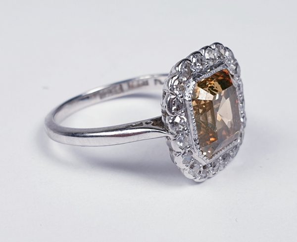 Asscher Cut Fancy Diamond Cluster Ring; central 2.76ct golden Asscher cut diamond set within a surround of 0.20cts old cut diamonds, in 18ct gold and platinum, Circa 1940