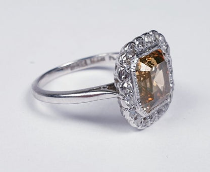 Asscher Cut Fancy Diamond Cluster Ring; central 2.76ct golden Asscher cut diamond set within a surround of 0.20cts old cut diamonds, in 18ct gold and platinum, Circa 1940