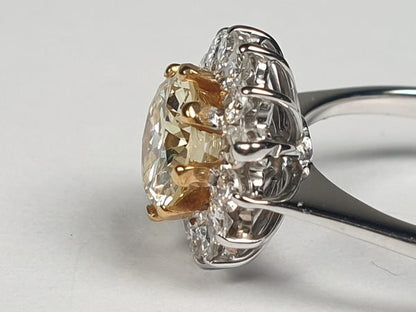 Old Cut Fancy Yellow Diamond Cluster Ring; featuring a 1.28 carat old European transitional cut fancy yellow diamond surrounded by a halo of sparkling white diamonds. Mounted in platinum