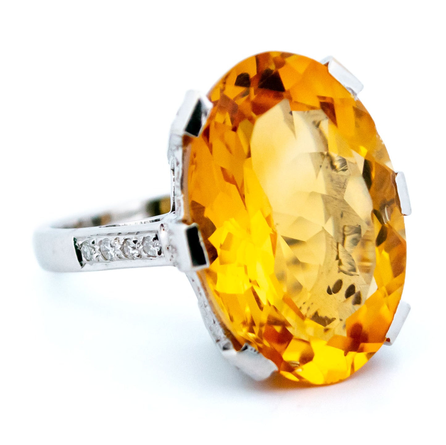A large statement ring featuring an oval citrine with diamond shoulders in white gold