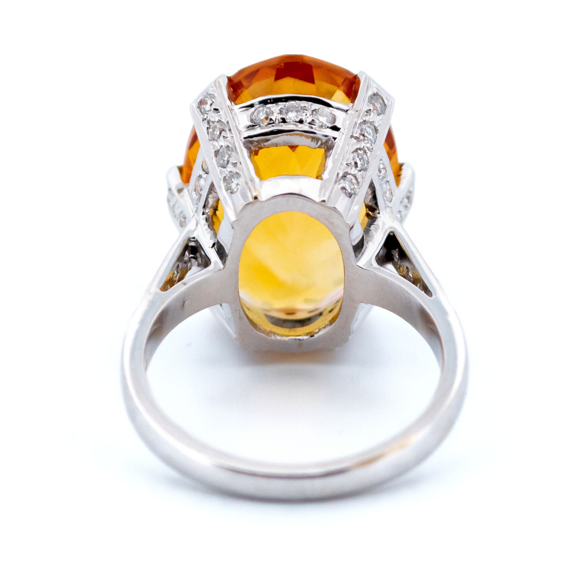 A large statement ring featuring an oval citrine with diamond shoulders in white gold