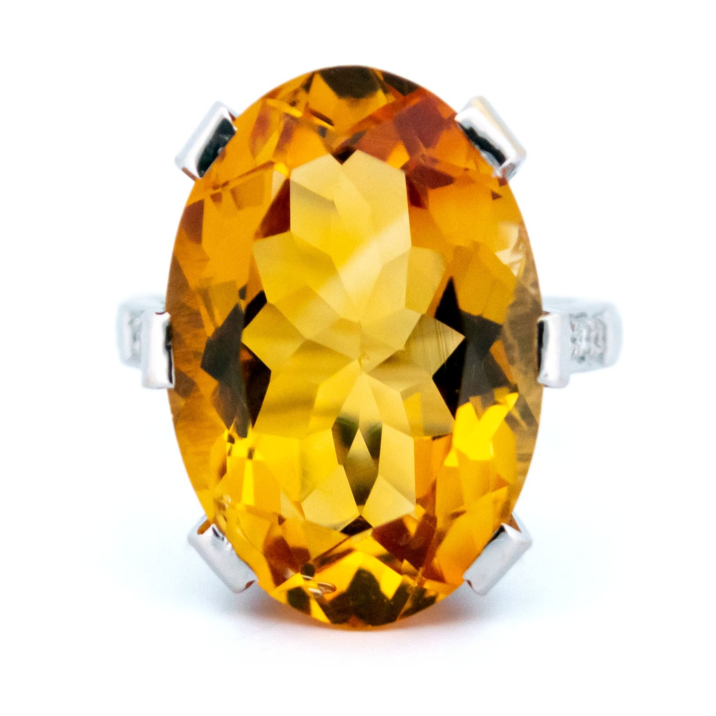 A large statement ring featuring an oval citrine with diamond shoulders in white gold