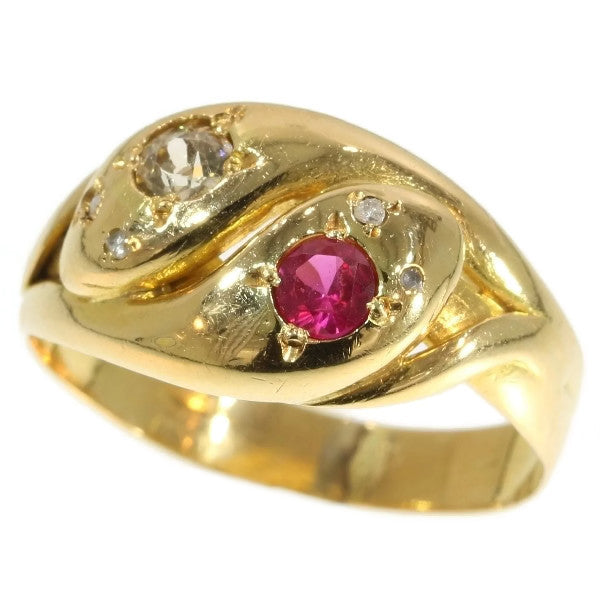 An antique gold double headed snake ring set with a ruby and diamond to each head and diamond set eyes. Mounted in 18ct gold.  