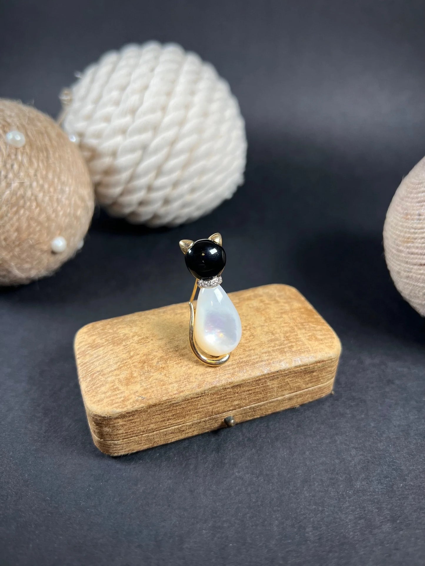 A cat-shaped brooch in yellow gold with black onyx, mother of pearl and a diamond set collar