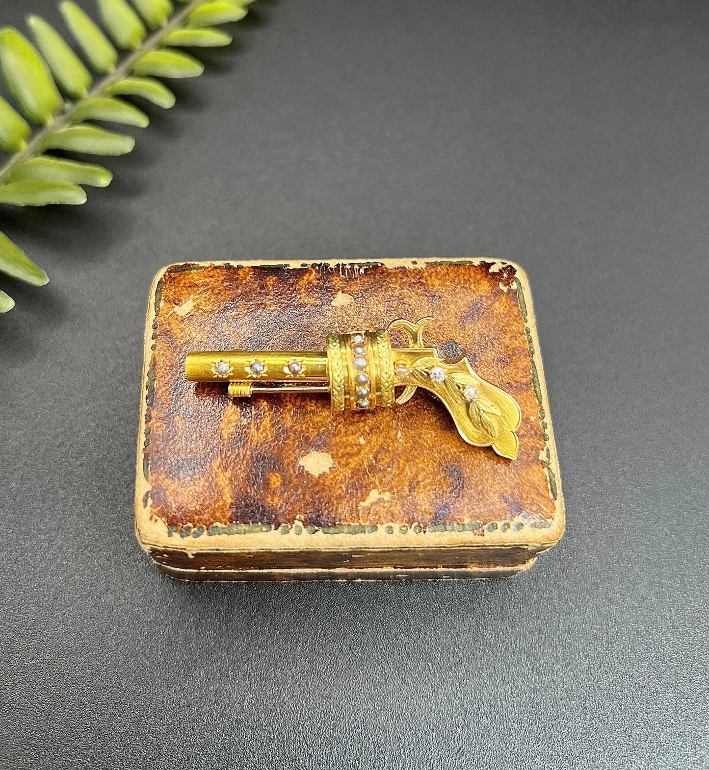 A yellow gold novelty gun brooch with diamonds and seed pearls