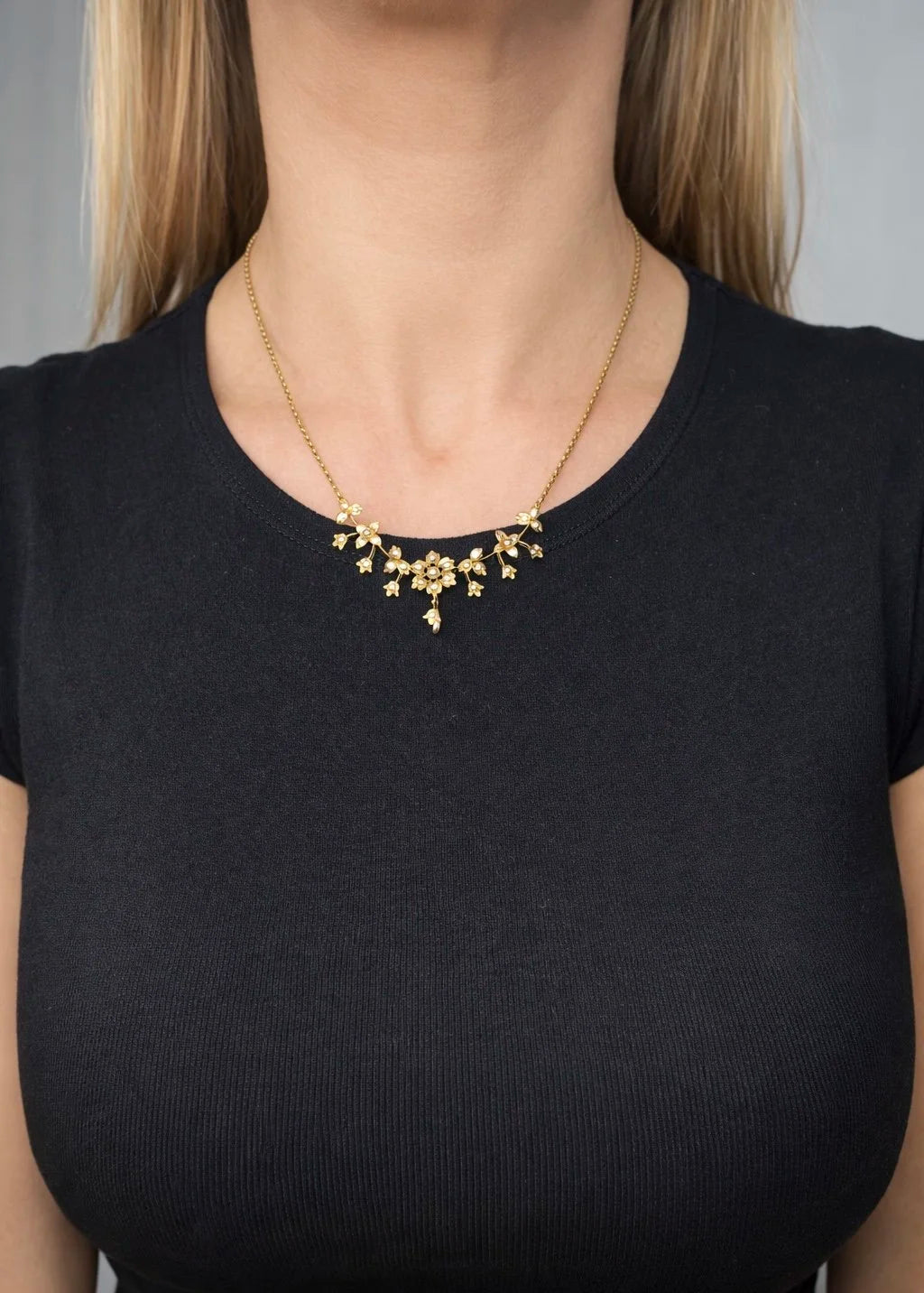 A yellow gold floral pendant necklace with seed pearls, modelled