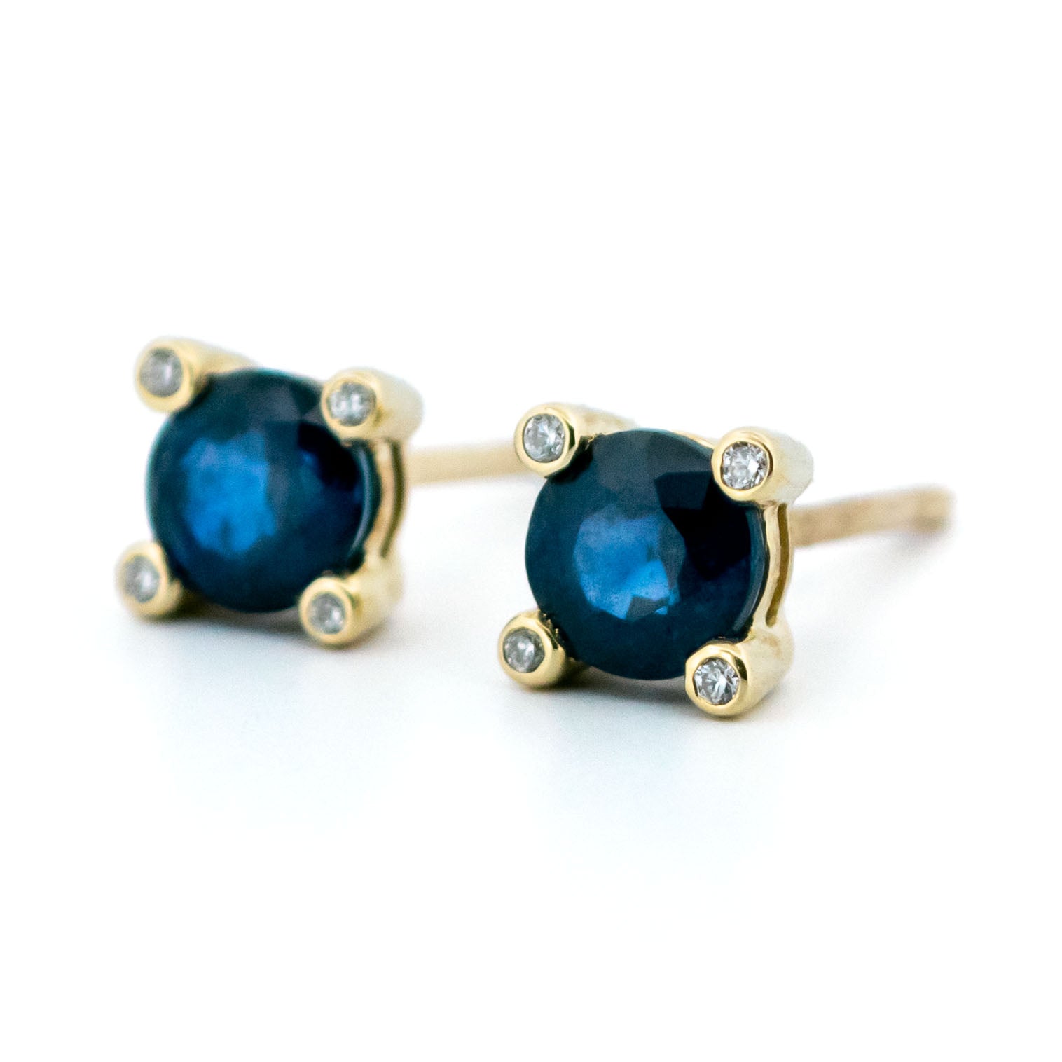 A pair of round sapphire and diamond stud earrings in yellow gold