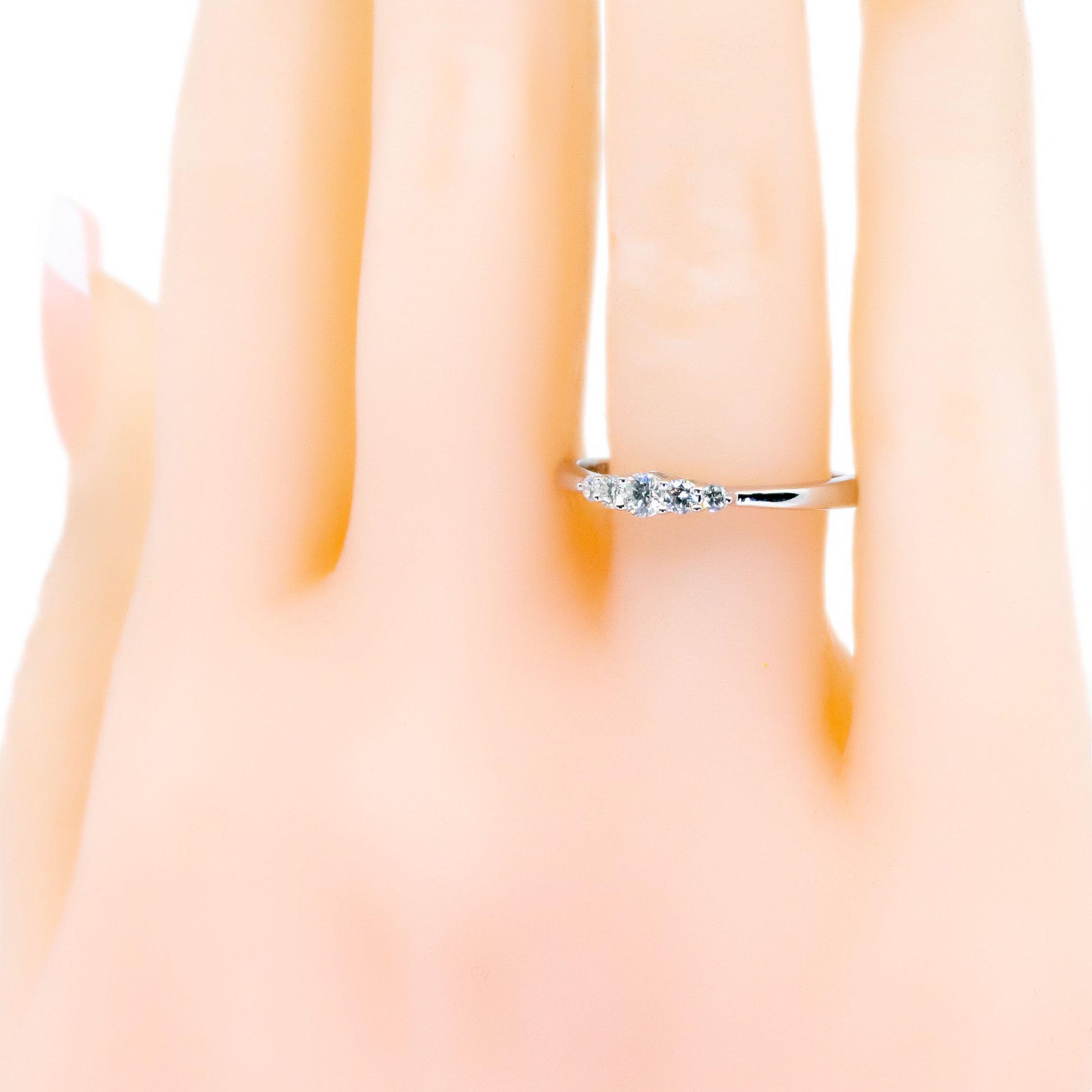 A graduated five stone diamond ring in white gold, modelled on a hand