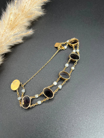 A yellow gold bracelet with oval cabochon garnets and white pearls