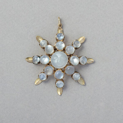 Victorian Antique Carved Moonstone Star Pendant, set with graduating cabochon-cut moonstones around central larger round moonstone with a carved smiling face of the ‘man in the moon’. Circa 1890