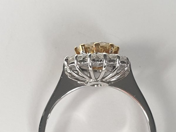 Old Cut Fancy Yellow Diamond Cluster Ring; featuring a 1.28 carat old European transitional cut fancy yellow diamond surrounded by a halo of sparkling white diamonds. Mounted in platinum