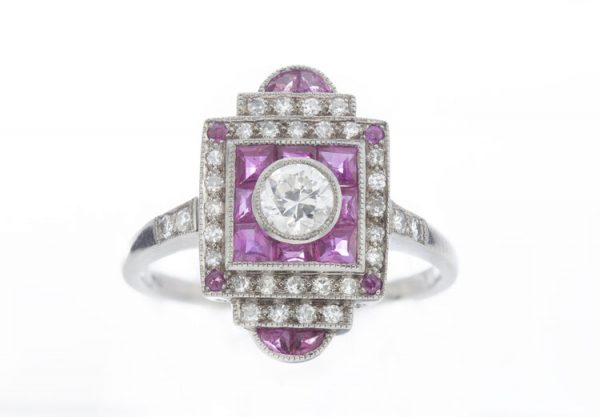 Vintage Art Deco Style Ruby and Diamond Cluster Plaque Ring; central 0.33ct round brilliant-cut diamond surrounded by mixed cut rubies and an outer border of sparkling diamonds. Mounted in 18ct white gold. Circa 1980s