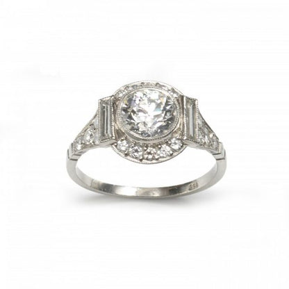 Art Deco Style Diamond Cluster Ring in Platinum; central 1.48ct H colour VS1 clarity round transitional brilliant cut diamond surrounded by a halo of brilliant and baguette cut diamonds, diamond set shoulders