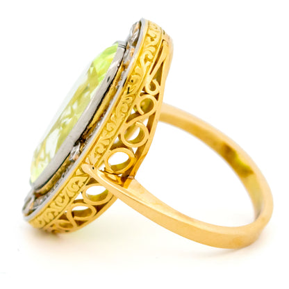 An oval spinel and rose cut diamond Art Deco design cluster dress ring in yellow gold and platinum, with a scrolled gallery, against a white background