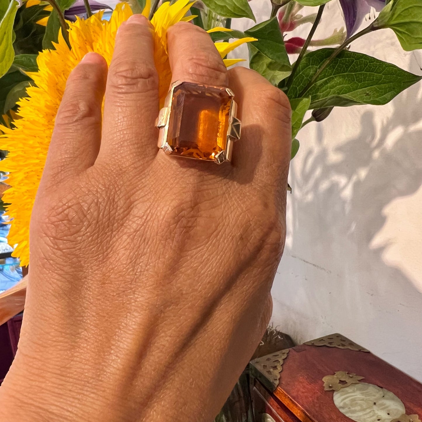 A large citrine solitaire dress ring in yellow gold, modelled on a hand