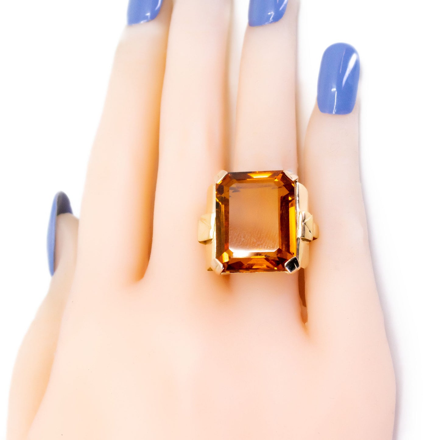 A large citrine solitaire dress ring in yellow gold, modelled on a hand