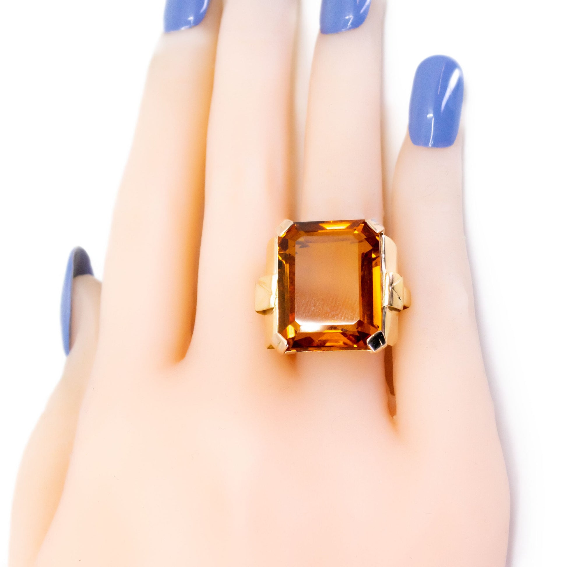 A large citrine solitaire dress ring in yellow gold, modelled on a hand