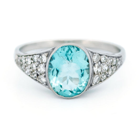 An oval aquamarine ring with graduated driamond shoulders, in platinum