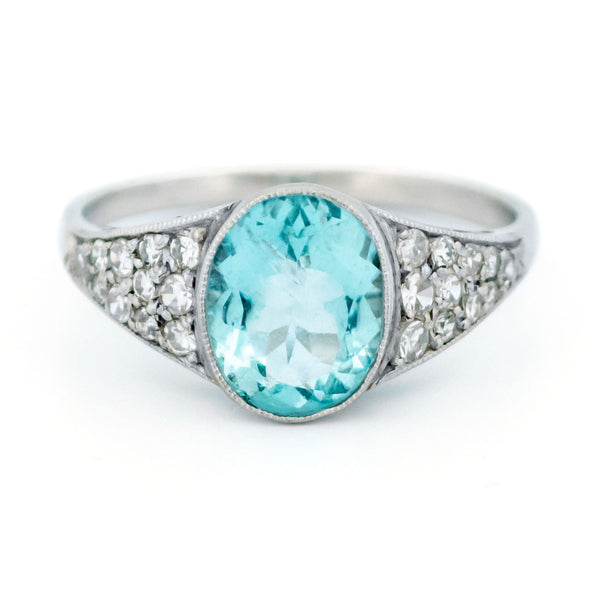 An oval aquamarine ring with graduated driamond shoulders, in platinum
