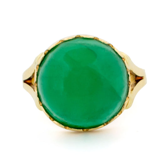 A solitaire cabochon cut emerald ring in yellow gold