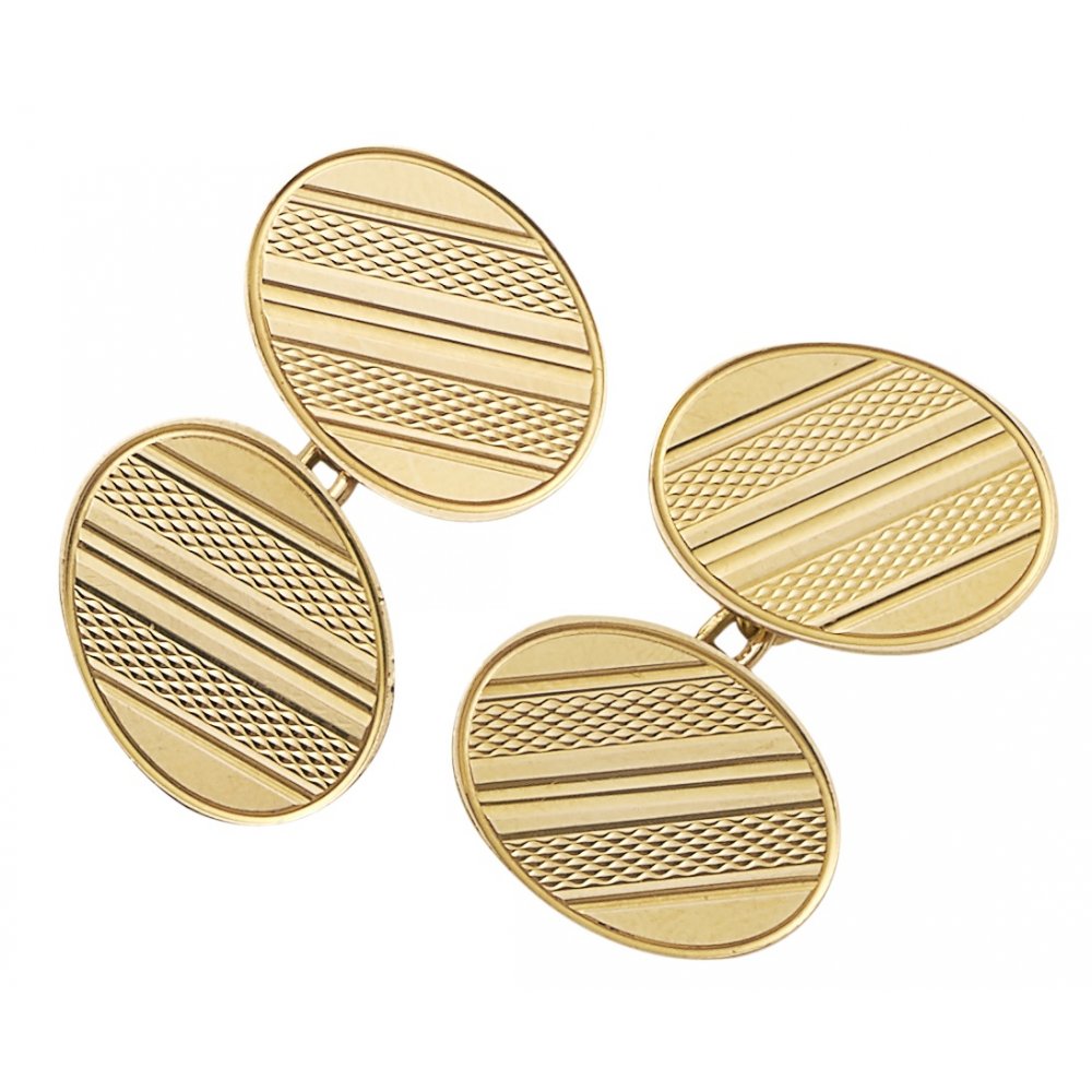 A pair of yellow gold oval shaped cufflinks with engine turned engraving, on a white background