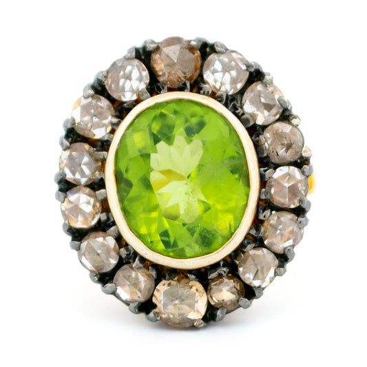 An oval peridot and diamond cluster ring in gold and silver
