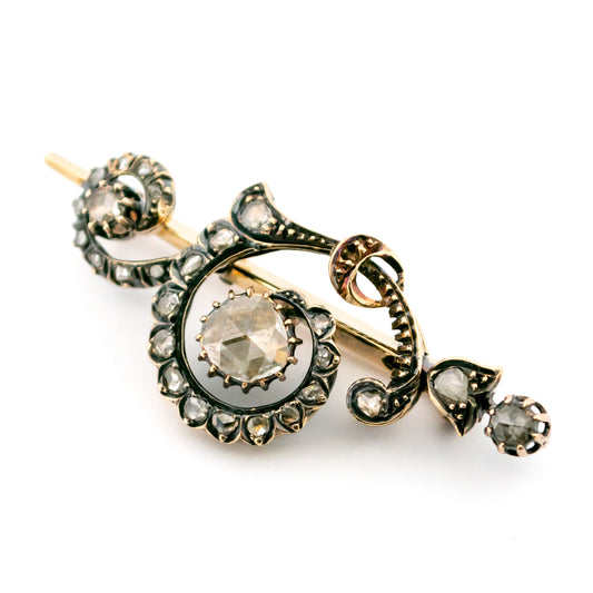 A rose-cut diamond scroll design brooch in gold and silver