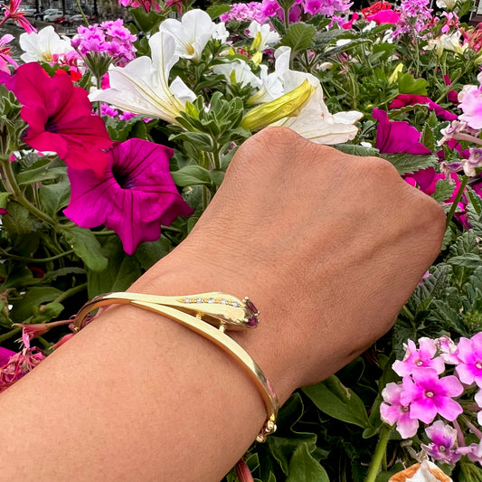 A yellow gold ruby and diamond snake bangle bracelet, modelled on a wrist