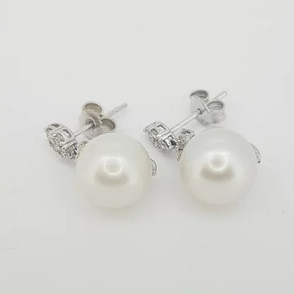 Pearl and Diamond Drop Earrings; each earring featuring a pearl suspended from a diamond-set marquise-shaped stud, in 18ct white gold