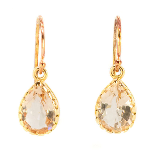 A pair of pear shaped morganite drop earrings in yellow gold