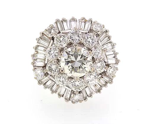 Vintage Diamond Cocktail Ring; central 1.80ct round cut diamond encircled by a double layer of 3.50cts round cut and baguette cut diamonds, 5.40 carat total, Circa 1960