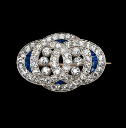 Art Deco Sapphire and Old Cut Diamond Brooch in Platinum; 4cts old European cut diamonds and 0.20cts natural sapphires, in platinum with intricate engraved edges, Circa 1920