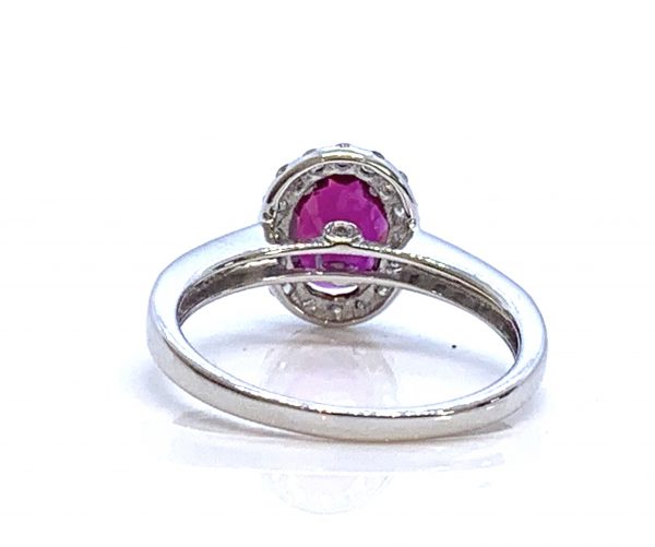 Burma Ruby and Diamond Cluster Ring; central 1.11ct oval faceted Burmese ruby with no indication of heat treatment set within a diamond halo, with diamond set shoulders, in 18ct white gold